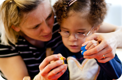 A woman and child playing with lego pieces.