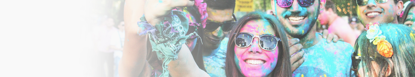 A group of friends standing together, all wearing sunglasses, whilst covered in paint.