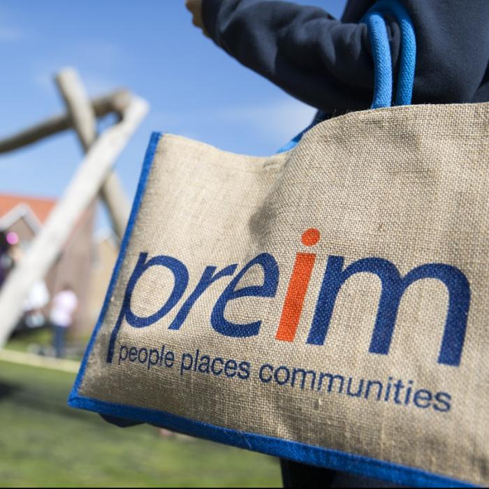 Someone holding a shopping bag while watching children play